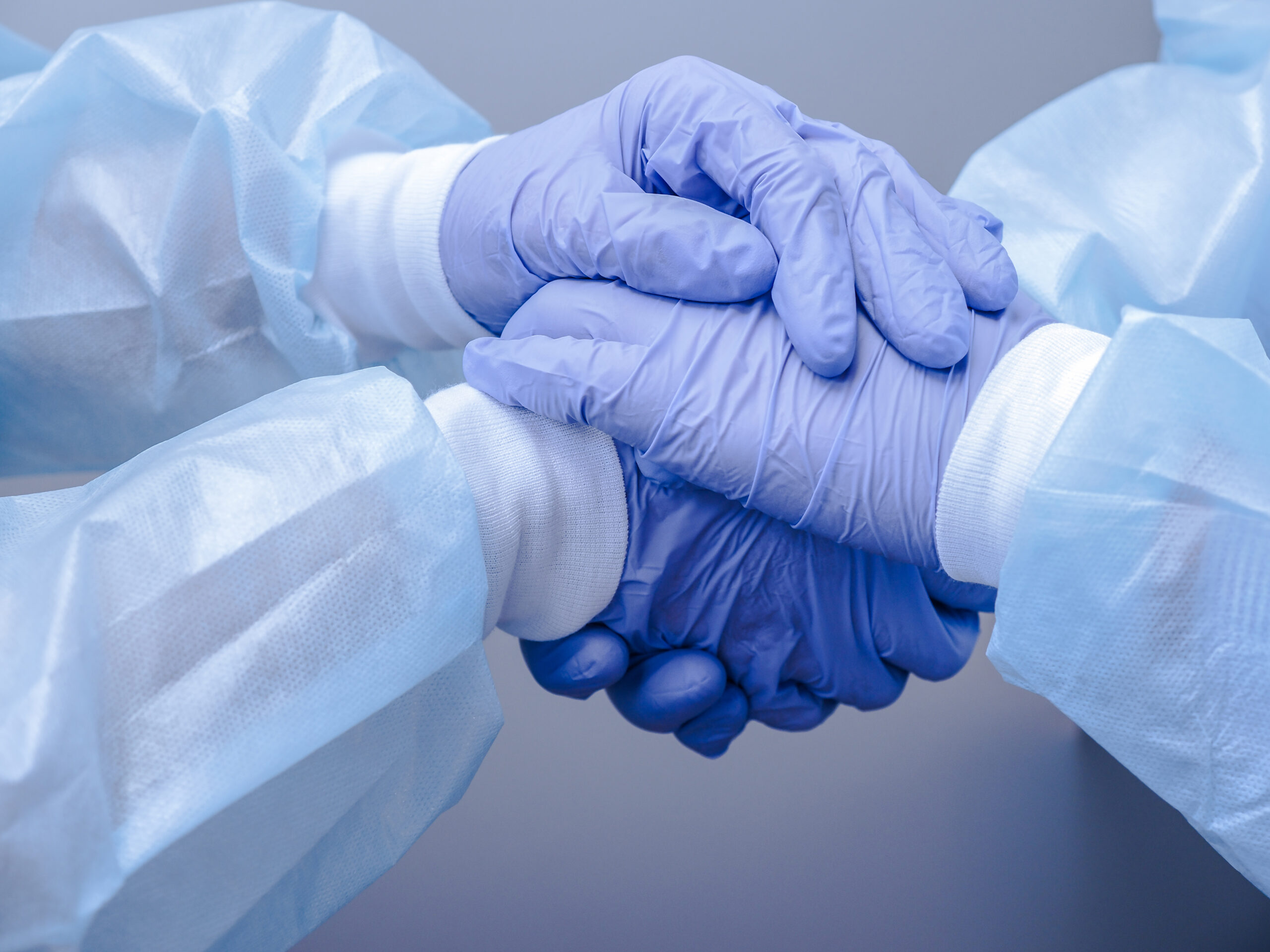 Handshake of two doctors' hands in medical gloves